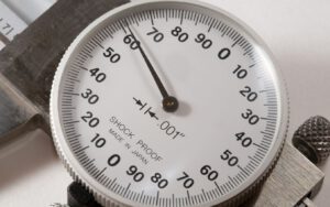 Close-up of a dial caliper gauge, showing a measurement of 0.001".