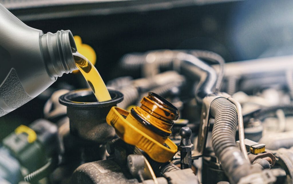 Pouring new motor oil into engine during oil change.