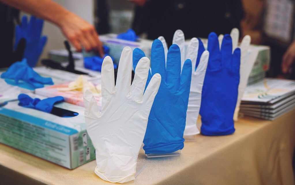 Assortment of blue and white nitrile disposable gloves displayed.