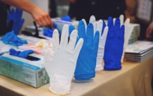 Assortment of blue and white nitrile disposable gloves displayed.