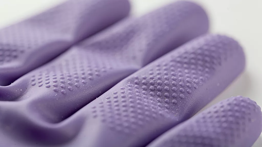 Close-up of textured nitrile glove fingertips showing grip pattern