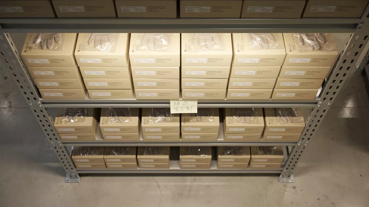 Organized storage shelves holding sealed nitrile glove boxes